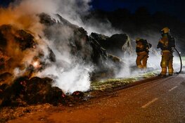Grasstapel in brand. Grote rookwolk boven wijk De Waal