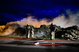 Grasstapel in brand. Grote rookwolk boven wijk De Waal
