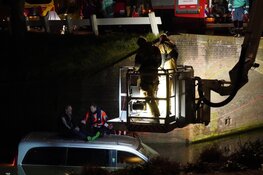 Bestelbus te water in Enkhuizen, bestuurder klimt op dak voertuig