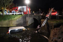 Bestelbus te water in Enkhuizen, bestuurder klimt op dak voertuig
