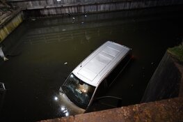 Bestelbus te water in Enkhuizen, bestuurder klimt op dak voertuig