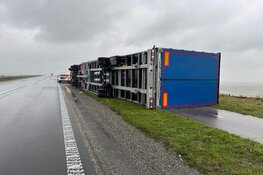 Vrachtwagen waait om door harde wind op de Markerwaarddijk