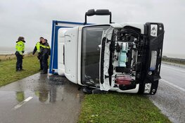 Vrachtwagen waait om door harde wind op de Markerwaarddijk