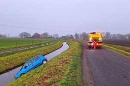 Automobilist raakt van de weg op modderig wegdek in Berkhout
