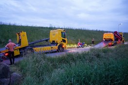 Twee motorrijders rijden van dijk in Venhuizen