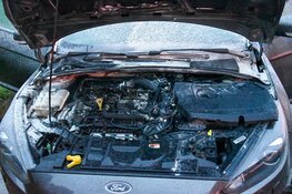 Automobilist blust eigen auto met poederblusser van tankstation