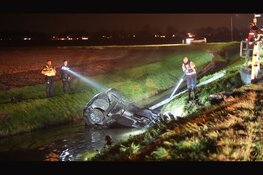 Auto over de kop aangetroffen in sloot. Brandweer zoekt naar inzittende