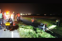 Auto over de kop aangetroffen in sloot. Brandweer zoekt naar inzittende