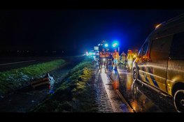 Auto ondersteboven in sloot op spiegelgladde weg, bestuurster met spoed naar ziekenhuis