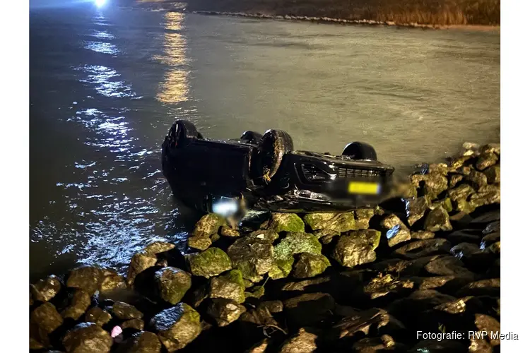 Auto met twee inzittenden op zijn kop te water langs de Zuiderdijk in Wijdenes