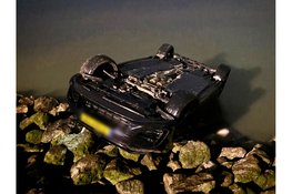 Auto met twee inzittenden op zijn kop te water langs de Zuiderdijk in Wijdenes
