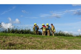 Maaimachine vliegt in brand tijdens maaien van dijk in Wervershoof