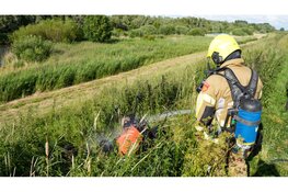 Maaimachine vliegt in brand tijdens maaien van dijk in Wervershoof