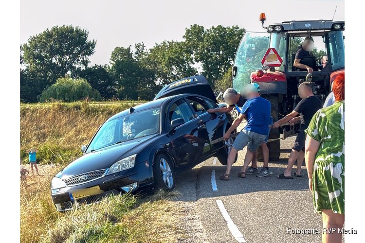 Spannende momenten voor inzittenden auto op de Zuiderdijk in Wijdenes, trekker haalt auto omhoog