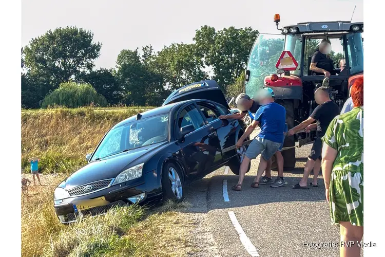 Spannende momenten voor inzittenden auto op de Zuiderdijk in Wijdenes, trekker haalt auto omhoog