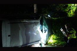Auto botst tegen boom en komt op zijkant tot stilstand in Oostwoud