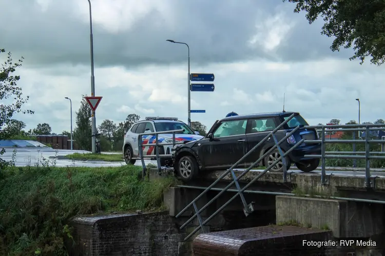 Auto botst tegen hekwerk van brug en komt boven water tot stilstand aan de Langereis